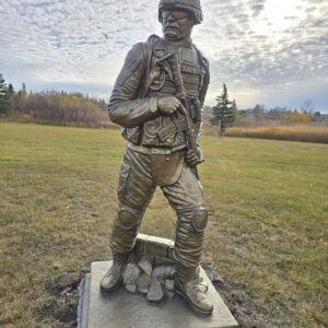 Statue of a soldier in a field.